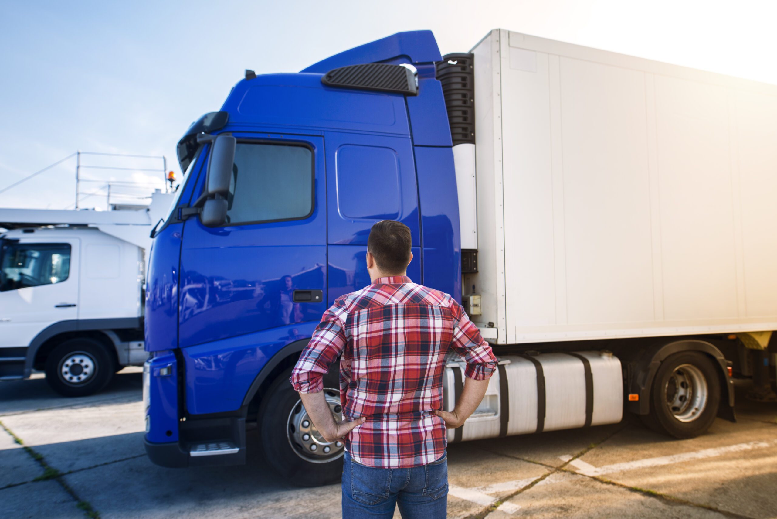 Professional middle aged truck driver in casual clothes looking at truck vehicle and going for a long transportation drive.